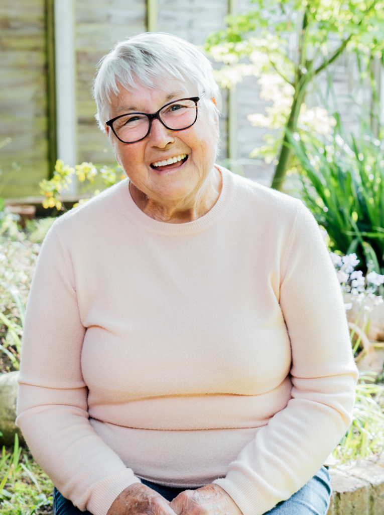 a woman smiling because she has dentures